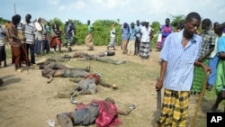 Des villageois regardent les corps de présumés assaillants, membres de la tribu Pokomo, au village de Kipao (21 déc. 2012)