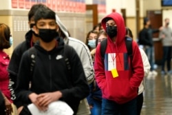 Students at Wyandotte County High School wear masks as they walk through a hallway on the first day of in-person learning at the school in Kansas City, Kansas, March 31. 2021.