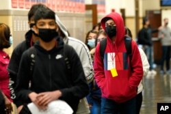Students at Wyandotte County High School wear masks as they walk through a hallway on the first day of in-person learning at the school in Kansas City, Kansas, March 31. 2021.