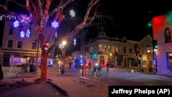 La police quadrille les rues du centre-ville de Waukesha, dans le Wisconsin, après qu'un véhicule a foncé dans une parade de Noël, heurtant plus de 20 personnes, dimanche 21 novembre 2021. 