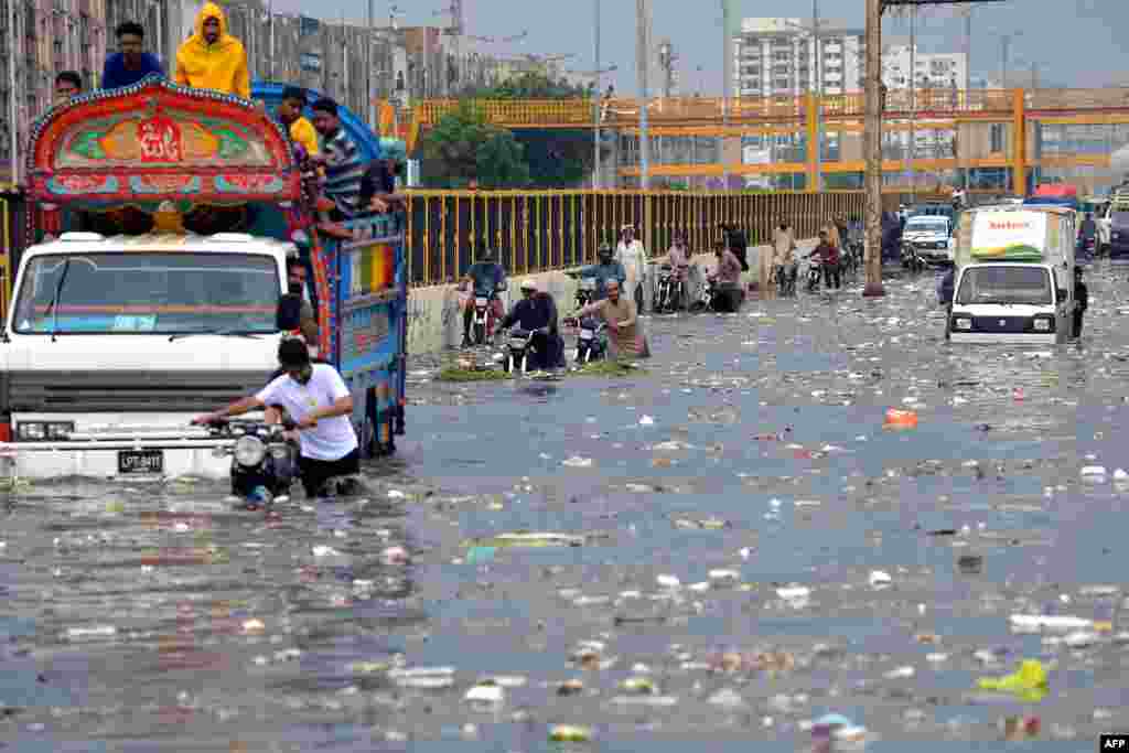 People wade through a flooded street after heavy monsoon rains in Karachi, Pakistan.