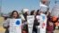 Teachers from Apollo elementary school in the Putnam City school district of Oklahoma City, wave signs at passing cars outside the state Capitol as protests over school funding continue for the third day in Oklahoma City, Wednesday, April 4, 2018. 
