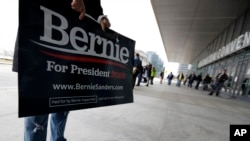 A supporter of Democratic presidential candidate Sen. Bernie Sanders, I-Vt., holds a sign outside the Huntington Convention Center of Cleveland before a campaign rally, March 10, 2020.