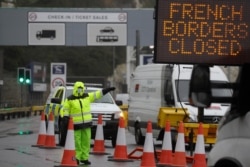 FILE - Security guard the entrance to the ferry terminal in Dover, England, Dec. 21, 2020, after the Port of Dover was closed and access to the Eurotunnel terminal suspended following the French government's announcement.