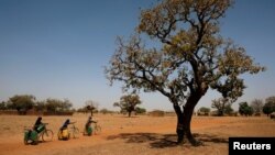 Des filles transportent de l'eau sur leurs vélos vers le village de Nedogo, près de Ouagadougou, au Burkina Faso, le 16 février 2018.