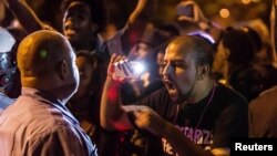 A demonstrator confronts a police officer in St. Louis, Missouri, Oct. 8, 2014, during protests following an incident in which a white off-duty policeman shot and killed a black teenager.