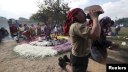 Yon prèt Maya ap soufle yon lanbi pandan dewoulman seremoni Oxlajuj Batz la pou l make fen klandriye Maya a (Vil Guatemala, 12 desanm 2012)