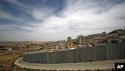 A section of the controversial Israeli barrier is seen from Jerusalem and shows the Shuafat refugee camp (R) in the West Bank near Jerusalem, and Pisgat Zeev (L) in an area Israel annexed to Jerusalem after capturing it in the 1967 Middle East war, May 25