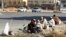 Foreign construction laborers rest on a street in Riyadh Dec. 3, 2012.