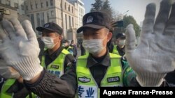 FILE - Police attempt to stop journalists outside the Shanghai Pudong New District People's Court, where Chinese citizen journalist Zhang Zhan is set for trial in Shanghai on Dec. 28, 2020.