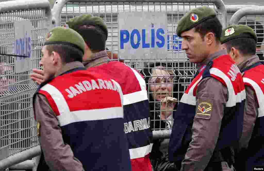 Pasukan keamanan Turki siaga sementara pengunjung menunggu di belakang penghalang keamanan di luar gedung pengadilan di Silivri, dekat Istanbul. Persidangan atas hampir 300 orang, yang dituduh berusaha menggulingkan pemerintahan PM Erdogan, dilanjutkan di kompleks penjara Silivri.