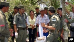Argentine Gendarmerie members speaking with locals next to packages of cocaine in a privately owned field. Locals noticed small planes flying low over a field for no apparent reason, authorities in Argentina found some 700 kilos (1,543 lbs.) of cocaine bu