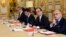 French President Francois Hollande, flanked by his Interior Minister Bernard Cazeneuve, right, and Prime Minister Manuel Valls, 2nd left, looks on during a meeting with French representatives of the different religion at the Elysee Palace in Paris, Wednes