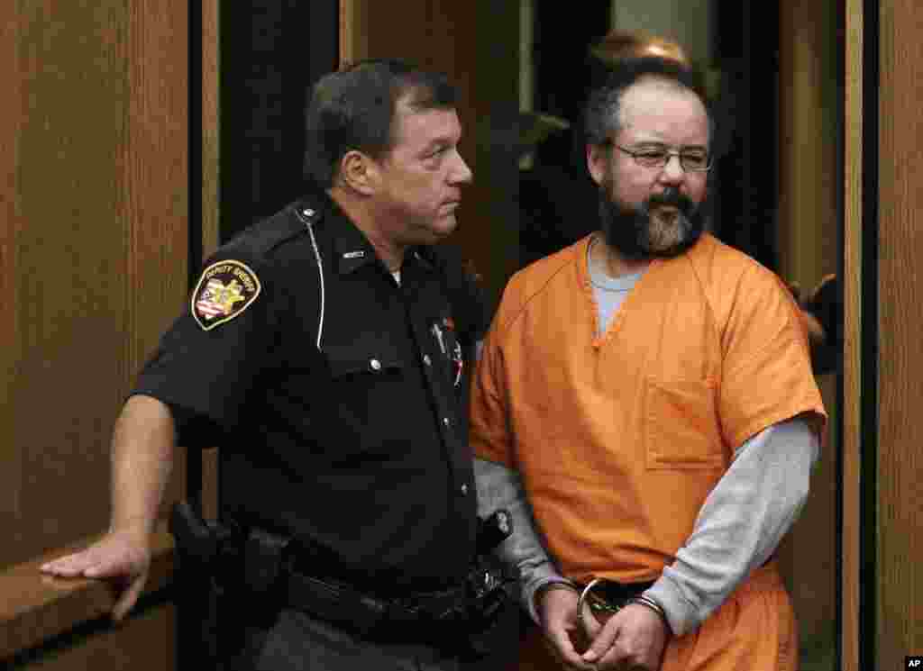 Ariel Castro, yang menyekap tiga perempuan di rumahnya selama bertahun-tahun, memasuki ruang sidang sambil diawasi petugas keamanan di Cleveland, Ohio (26/7). (AP/Tony Dejak)