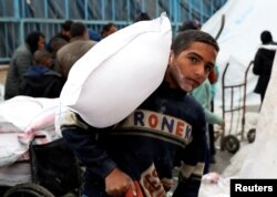 FILE —A Palestinian boy carries a bag of flour distributed by the United Nations Relief and Works Agency (UNRWA), amid the ongoing conflict between Israel and Hamas, in Rafah in the southern Gaza Strip January 29, 2024.