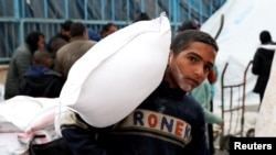 FILE—A Palestinian boy carries a bag of flour distributed by the United Nations Relief and Works Agency (UNRWA), amid the ongoing conflict between Israel and Hamas, in Rafah in the southern Gaza Strip January 29, 2024.