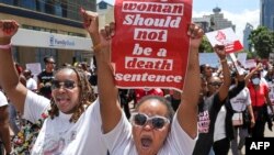 FILE -Activists hold up placards as they march through the Central Business District at a demonstration against an alarming rise in murders of young women in Nairobi on January 27, 2024.