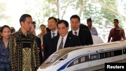 Presiden Joko Widodo (kedua dari kiri) dan Manajer Umum China Railway Corp. Sheng Guangzu (tengah) berdiri di sebelah model kereta api dalam acara peletakan batu pertama proyek kereta cepat Jakarta-Bandung di Walini, Jawa Barat, 21 Januari 2016.