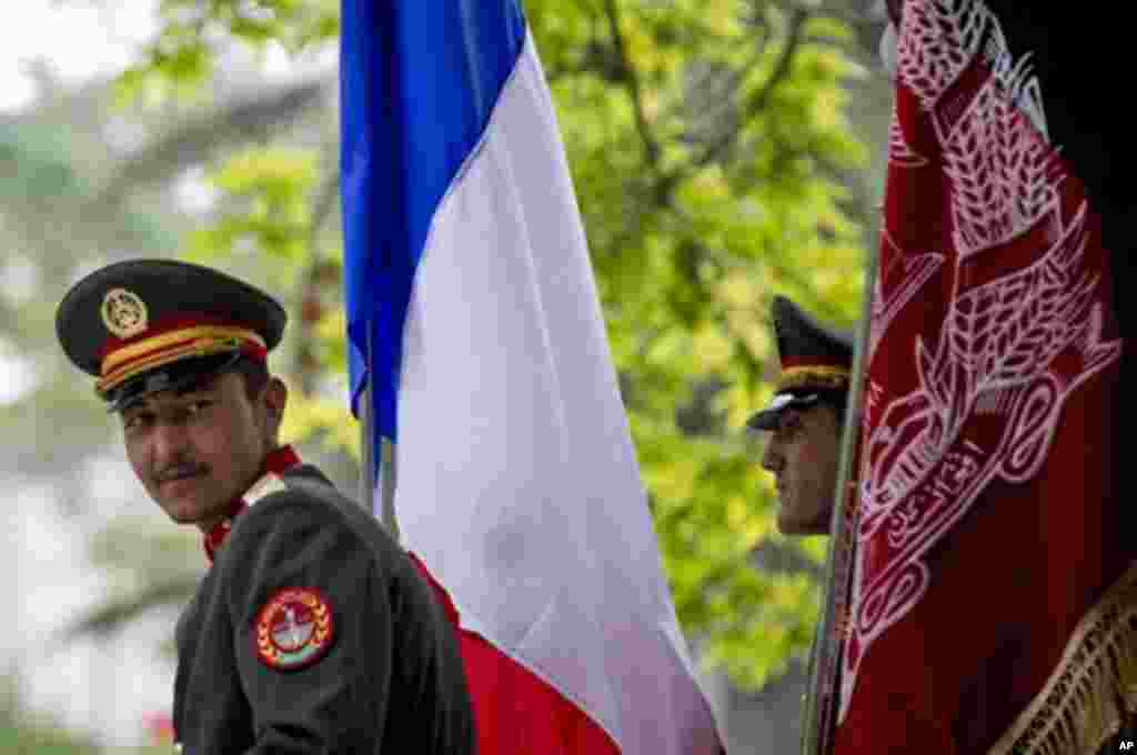Afghan honor guards sit next to the French and Afghan flag waiting for the start of the press conference  of French President Francois Hollande and  Afghan President Hamid Karzai at the Presidential Palace in Kabul, Afghanistan, Friday, May 25, 2012.  Hol