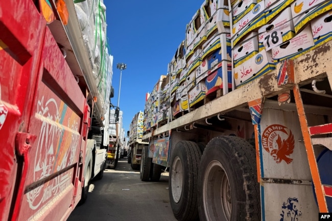 Truk-truk yang membawa bantuan kemanusiaan antre di sisi Mesir di perbatasan Rafah dengan Jalur Gaza pada 2 Maret 2025, setelah Israel menangguhkan masuknya pasokan ke wilayah Palestina. (Foto: AFP)