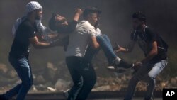 Palestinians carry an injured man during clashes with Israeli troops after a protest in solidarity with Palestinian prisoners on hunger strike in Israeli jails, in the West Bank city of Ramallah, May 11, 2017.