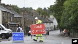 Petugas membuka kembali kawasan Whaley Bridge, Inggris, Rabu, 7 Agustus 2019. Daerah tersebut semula ditutup akibat bobolnya waduk Toddbrook yang dipicu oleh hujan lebat yang melanda kawasan tersebut.
