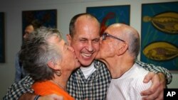 Wartawan Australia Peter Greste dipeluk orangtuanya Lois dan Juris saat tiba di Brisbane, Australia (5/2). (AP/Tertius Pickard)