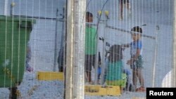 FILE - An undated supplied image from Amnesty International claiming to show children playing near a fence at the country's Australian-run detention centre on the Pacific island nation of Nauru. 