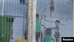 FILE - An undated image provided by Amnesty International purportedly shows children playing near a fence at an Australian-run detention center in the Pacific island nation of Nauru. 