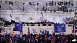 Demonstran yang merupakan pendukung loyalis Presiden Donald Trump menyerbu Gedung Capitol di Washington, pada 6 Januari 2021. (Foto: AP/John Minchillo)