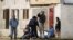 FILE - Individuals consume beer on the streets of Whiteclay, Nebraska, June 7, 2003. The unincorporated town of 12 people sells 4 million cans of beer a year, mostly to residents of the nearby Pine Ridge Indian Reservation. 