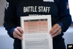 A booklet held by military and national security officials during an exercise for state and local election officials to simulate different scenarios for the 2020 elections, in Springfield, Va., Dec. 16, 2019.