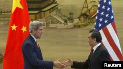 U.S. Secretary of State John Kerry, left, and Chinese Foreign Minister Wang Yi shake hands after a news conference following meetings at the Ministry of Foreign Affairs in Beijing, May 16, 2015. 