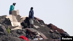 Migrants gather cardboard to build makeshift shelters near the former "Jungle" in Calais, France, June 1, 2017.