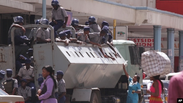 A truckload of Zimbabwean police is seen outside the headquarters of Zimbabwe's main opposition party in Harare March 12, 2015. Police sealed the building as tensions rose over the disappearance of activist Itai Dzamara.