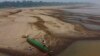 Reis Santo Vieira paints a boat on a dry part of the Madeira River, a tributary of the Amazon River, during the dry season in Humaita, Amazonas state, Brazil, Sept. 7, 2024. 