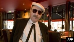 Leon Redbone ນັກ​ຮ້ອງ​ທີ່​ຫລິ້ນ​ກິດ​ຕາ​ໄປ​ພ້ອມ ຖ່າຍ​ຮູບ​ຢູ່​ຮ້ານ​ອາ​ຫານ​ແຫ່ງ​ນຶ່ງ​ໃນ​ນະ​ຄອນປາ​ຣີ, ວັນ​ທີ 15 ກັນ​ຍາ 2005. ຜູ້​ກ່ຽວ​ເສຍ​ຊີ​ວິດ​ໃນ​ວັນ​ທີ 30 ພຶດ​ສະ​ພາ, 2019, ອີງ​ຕາມ​ການ​ປະ​ກ​າດ​ຂອງ​ພີ່​ນ້ອງ​ລາວ ຢູ່​ໃນ​ເວັບ​ໄຊ​ທ໌​ຂອງ​ລາວ