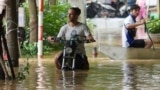 A man pushes his motorbike in a flooded street in the aftermath of Typhoon Yagi, in Hanoi, Vietnam, Sept. 12, 2024. 