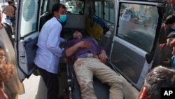 A man who was injured in a deadly suicide bombing that targeted a training class in a private building in the Shiite neighbourhood of Dasht-i Barcha, is placed in an ambulance in western Kabul, Afghanistan, Wednesday, Aug. 15, 2018. 
