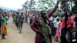 FILE - A Congolese army soldier responds to cheers from civilians as the army enters the town of Bunagana, eastern Congo, near the border with Uganda, Oct. 30, 2013. 