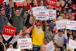 Supporters hold up signs as President Donald Trump speaks at a campaign rally in Bossier City, La., Nov. 14, 2019.