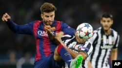 Gerard Piqué de Barcelone, à gauche, face à Carlos Tevez de la Juventus pendant le match de football finale de la Ligue des champions entre la Juventus Turin et le FC Barcelone au stade olympique de Berlin, le samedi 6 Juin 2015. (AP Photo / Frank Augstein, FILE)