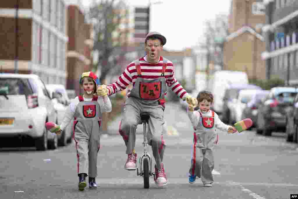 A clown on a unicycle (C) performs ahead of the annual Grimaldi Memorial Service at the All Saints church in east London. The service takes place to celebrate the father of modern clowning, Joseph Grimaldi, who died in 1837.