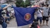 Para pengunjuk rasa bersiap untuk membakar bendera kelompok Perhimpunan Bangsa-Bangsa Asia Tenggara (ASEAN), saat mereka mengambil bagian dalam demonstrasi flash mob menentang kudeta militer di Yangon. (Foto: AFP)