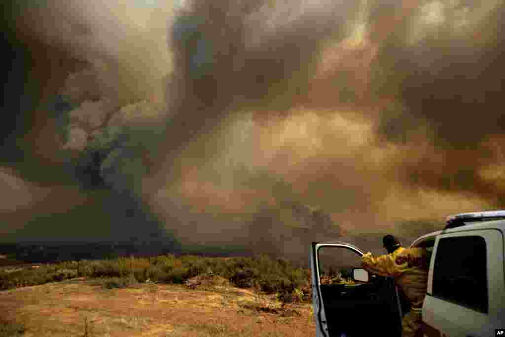 Cal Fire Division Chief Mark Higgins directs helicopters dropping water as the River Fire burns in Lakeport, California, July 31, 2018.