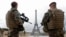 FILE - French army paratroopers patrol near the Eiffel tower in Paris, France, March 30, 2016. French authorities are extending a state-of-emergency they imposed after the November 2015 terror attacks that killed 130 people.