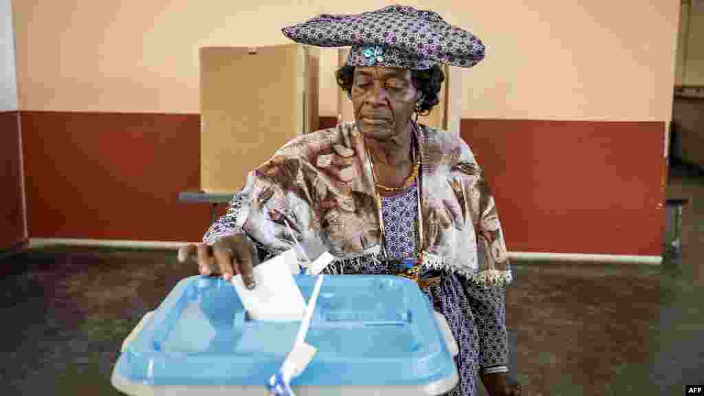 A pistillate   casts her ballot  astatine  a polling presumption    successful  Windhoek, Namibia, during extended voting pursuing  the country's wide   election.