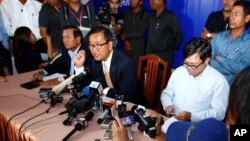 Cambodia National Rescue Party President Sam Rainsy, center, speaks during a press conference in his main party headquarters in Chak Angre Leu in Phnom Penh, Cambodia, July 29, 2013. 