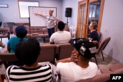 Volunteer Hope Kaufman leads Haitian students during an English class in Springfield, Ohio, Sept. 13, 2024. Bomb threats and early business closings are occurring the city because of the spread of racist rumors targeting its Haitian immigrant community.