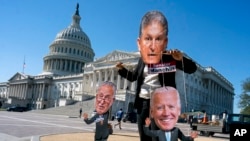 A climate change demonstrator mocks Sen. Joe Manchin, D-W.Va., who has blocked President Joe Biden's domestic agenda, at the Capitol in Washington, Oct. 20, 2021.